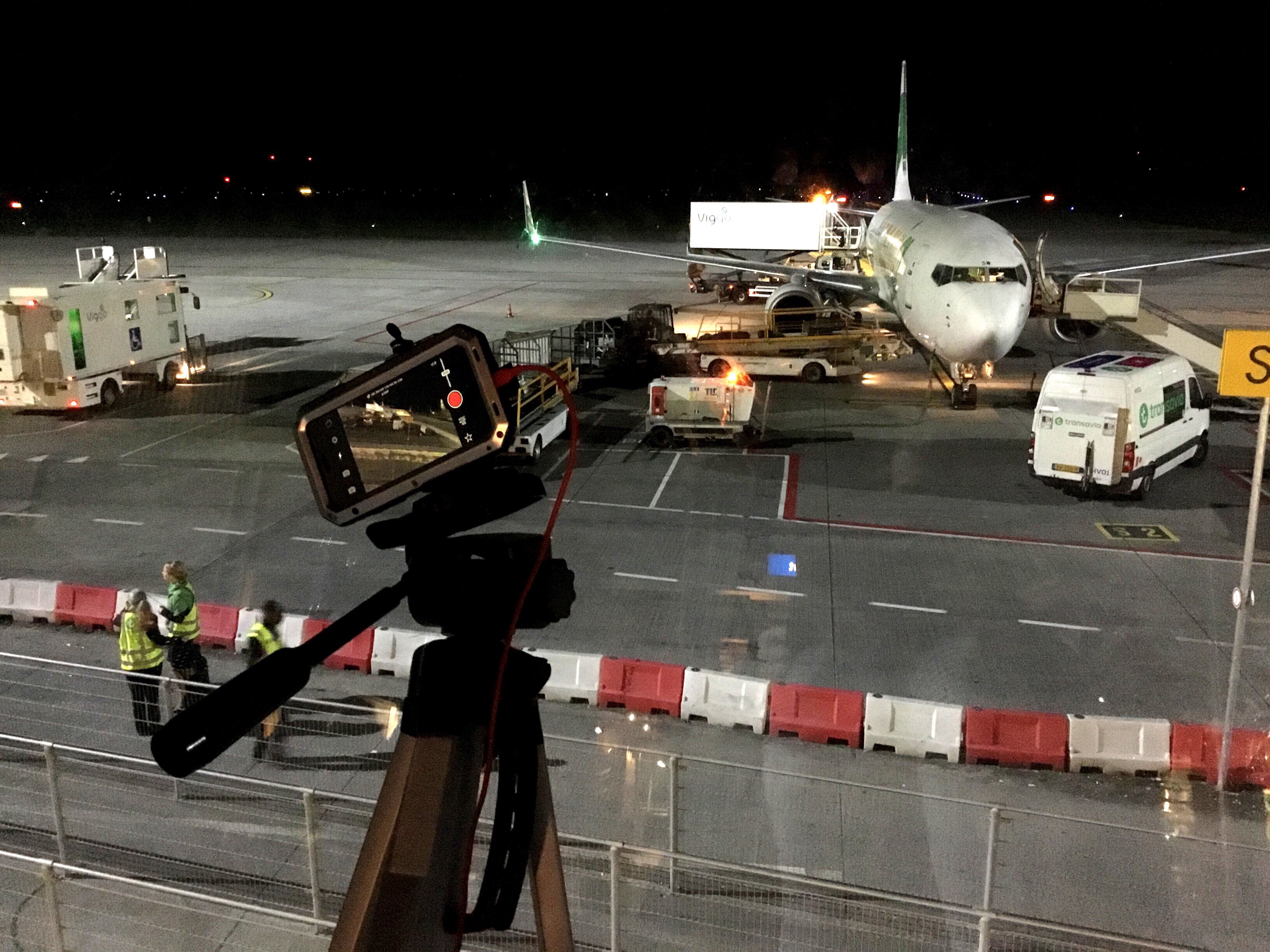 The phone set up on a tripod overlooking the airport gates from the panorama terrace